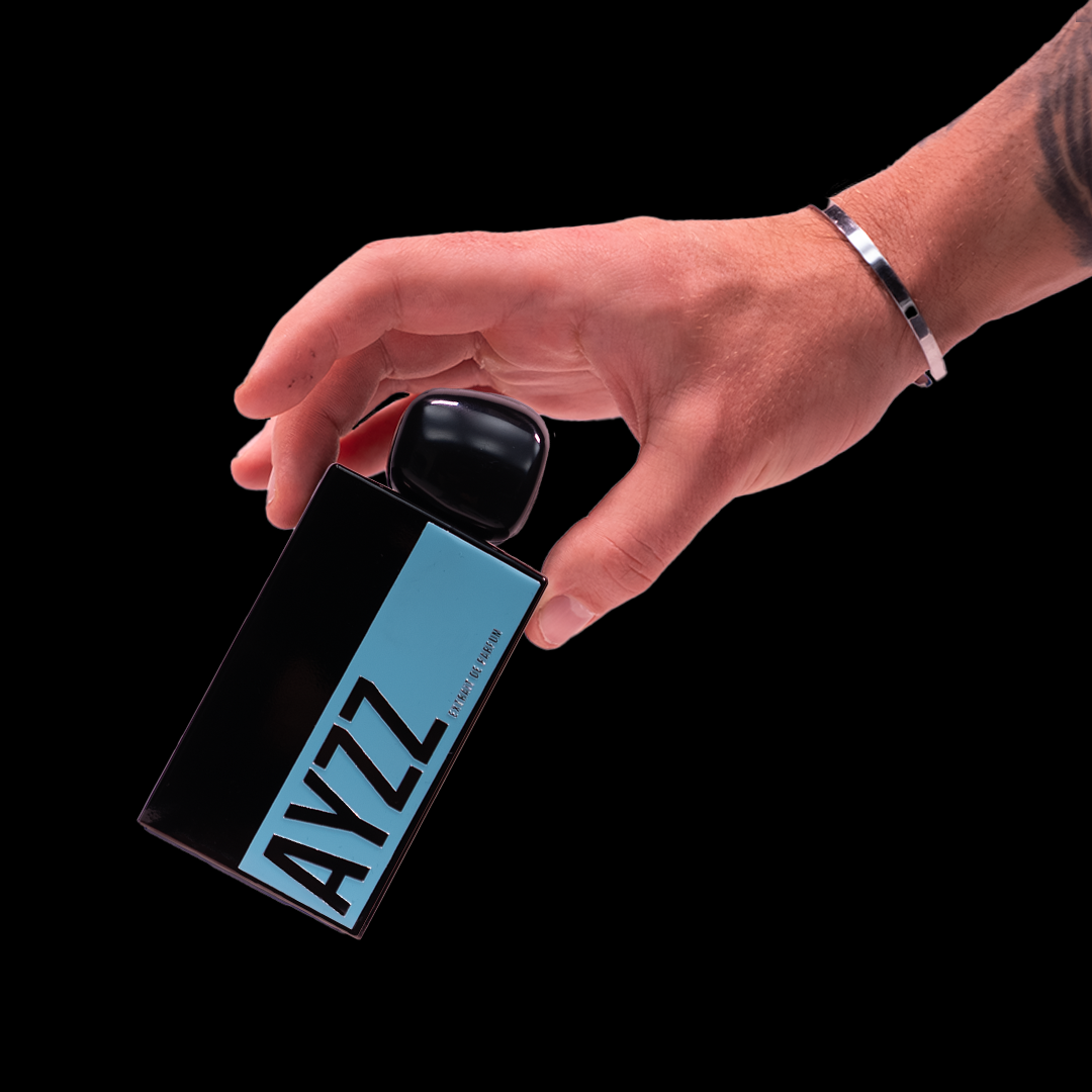 NIMORI AYZZ Flakon in der Hand – schwarzer Glasflakon mit türkiser Metallplatte. Frischer Duftmoment mit Zitrusnoten, Vanille und weißem Moschus.